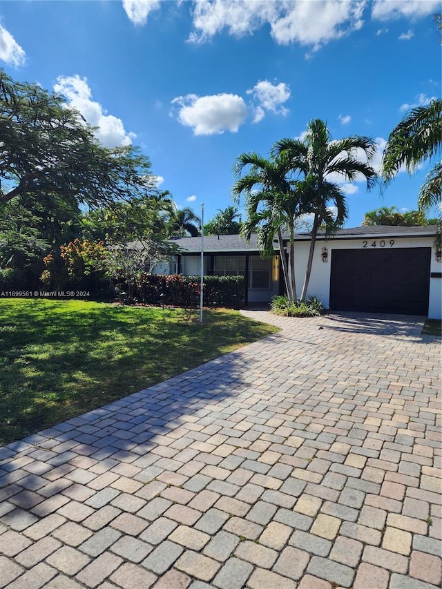 single story home featuring a garage and a front lawn