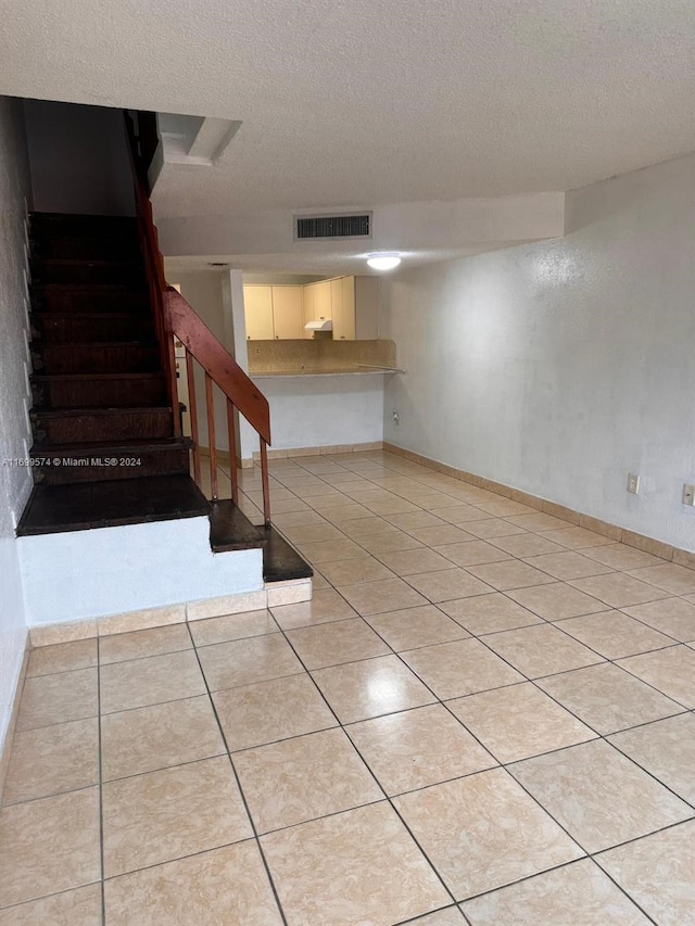 interior space with light tile patterned floors and a textured ceiling