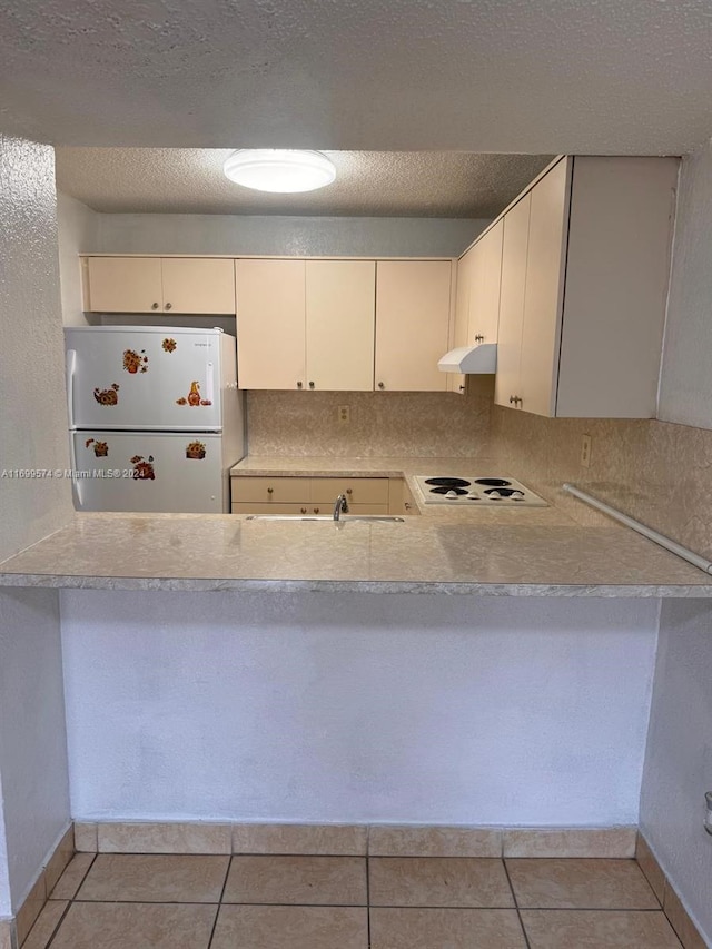 kitchen featuring white cabinets, light tile patterned floors, white appliances, and backsplash