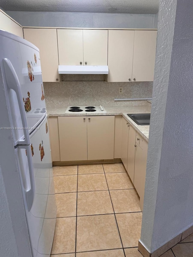 kitchen featuring backsplash, light tile patterned flooring, white appliances, and sink