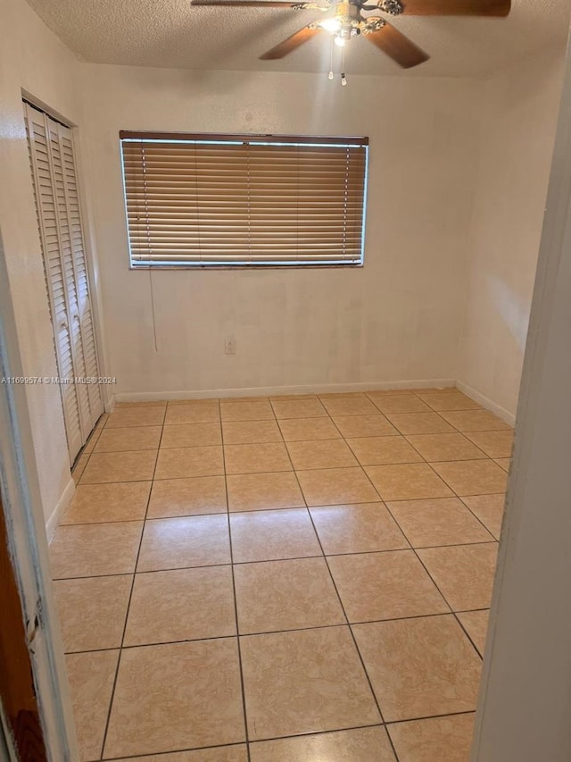 tiled empty room with a textured ceiling