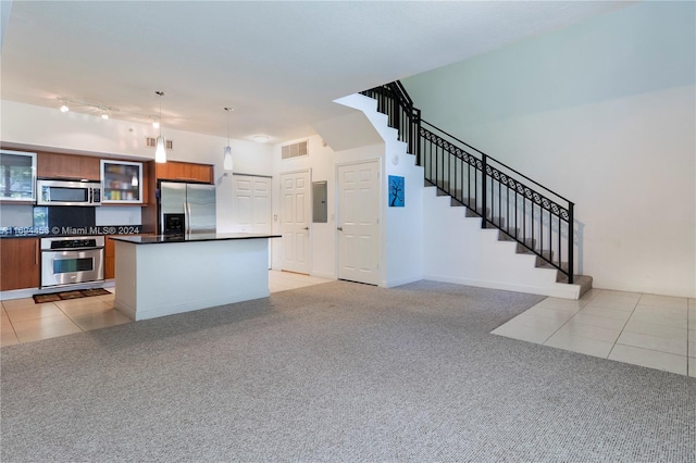 kitchen with stainless steel appliances, light tile patterned floors, decorative light fixtures, a center island, and electric panel