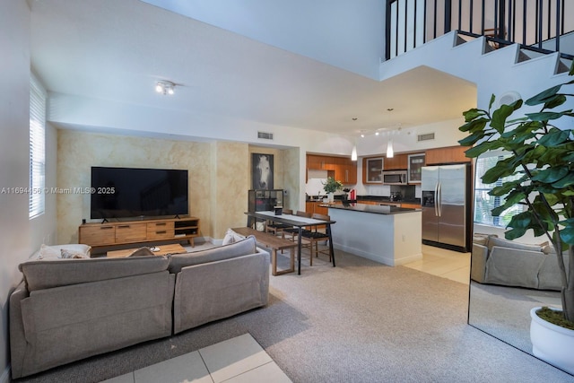 living area featuring light carpet and stairway