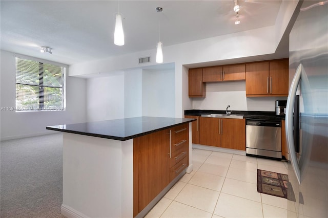 kitchen with sink, a center island, hanging light fixtures, light carpet, and appliances with stainless steel finishes