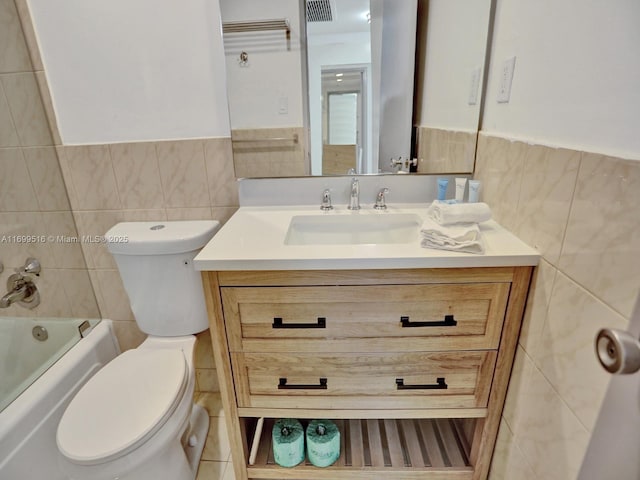 full bathroom with tile walls, vanity, toilet, and shower / bath combination