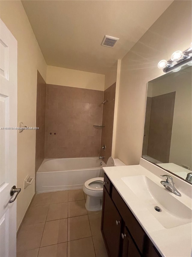 full bathroom with tile patterned flooring, vanity, tiled shower / bath combo, and toilet