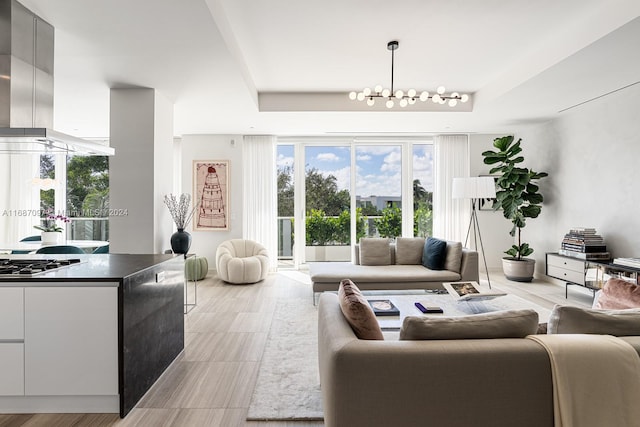 living room featuring a raised ceiling and an inviting chandelier