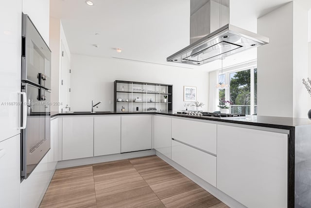 kitchen with white cabinets, island range hood, and stainless steel appliances