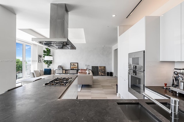 kitchen featuring white cabinetry, stainless steel appliances, and island range hood