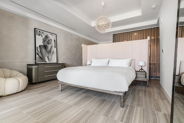 bedroom with a raised ceiling and a chandelier