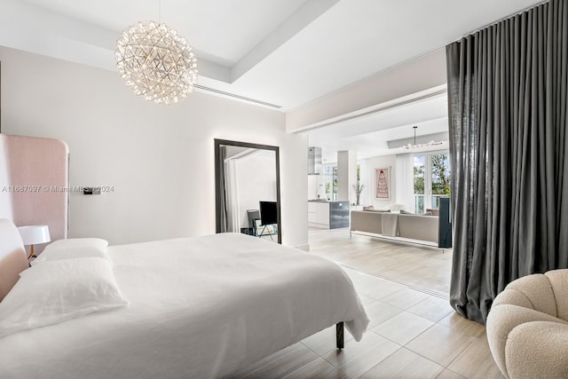 bedroom featuring a raised ceiling, light wood-type flooring, and a chandelier