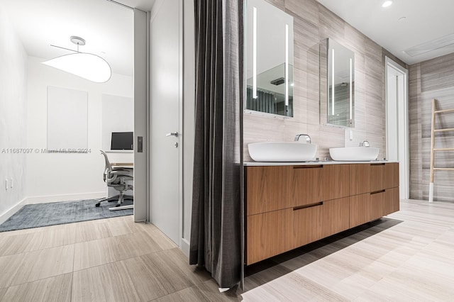 bathroom featuring vanity and tile walls