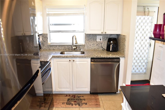 kitchen featuring white cabinetry, sink, light stone counters, decorative backsplash, and appliances with stainless steel finishes