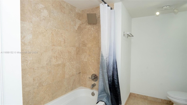 bathroom featuring tile patterned floors, shower / bath combo with shower curtain, and toilet