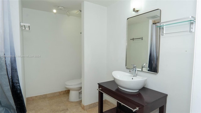 bathroom featuring tile patterned flooring, toilet, and sink