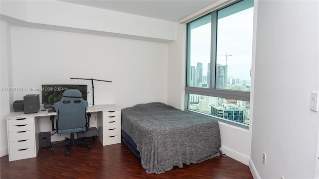 bedroom with dark hardwood / wood-style flooring and multiple windows