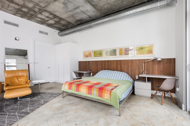 bedroom with a closet, visible vents, and concrete flooring