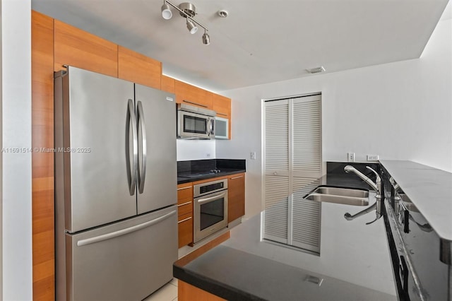 kitchen featuring sink, stainless steel appliances, and rail lighting