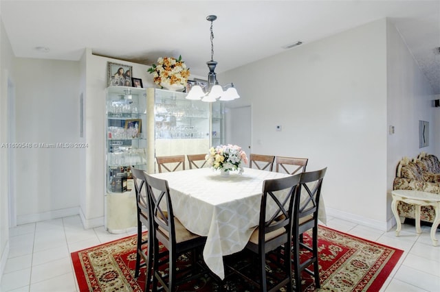 tiled dining space with an inviting chandelier