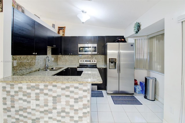 kitchen featuring kitchen peninsula, tasteful backsplash, stainless steel appliances, sink, and lofted ceiling