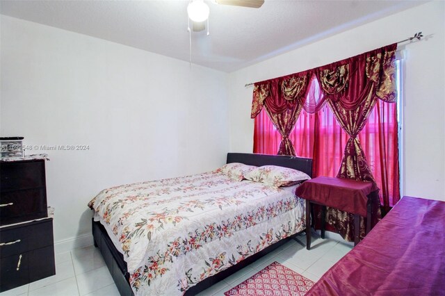 tiled bedroom featuring ceiling fan