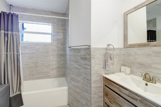 bathroom with vanity, shower / bath combination with curtain, and tile walls