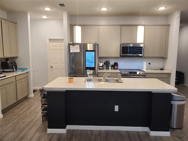 kitchen featuring appliances with stainless steel finishes, a center island with sink, pendant lighting, and sink