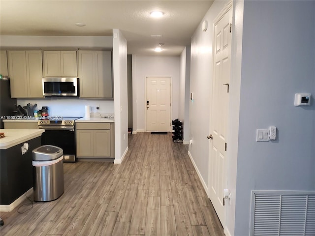 kitchen featuring appliances with stainless steel finishes and light hardwood / wood-style flooring