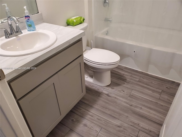 full bathroom with vanity, hardwood / wood-style flooring, toilet, and tub / shower combination