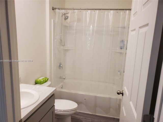 full bathroom with hardwood / wood-style floors, vanity, toilet, and shower / bath combo with shower curtain