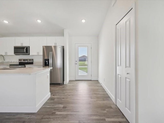 kitchen with dark wood-type flooring, white cabinets, and stainless steel appliances