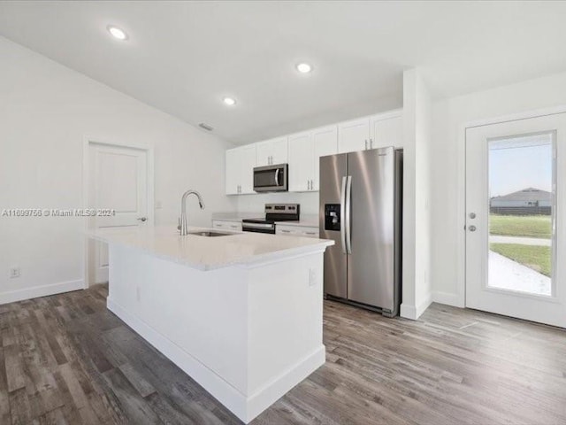 kitchen with white cabinetry, sink, stainless steel appliances, dark hardwood / wood-style floors, and a center island with sink