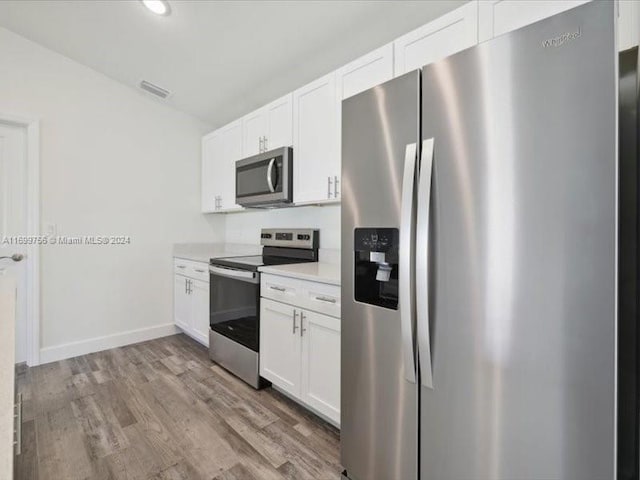 kitchen featuring light wood-type flooring, stainless steel appliances, and white cabinetry