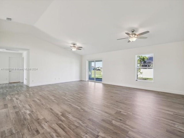 spare room with wood-type flooring, lofted ceiling, and a healthy amount of sunlight