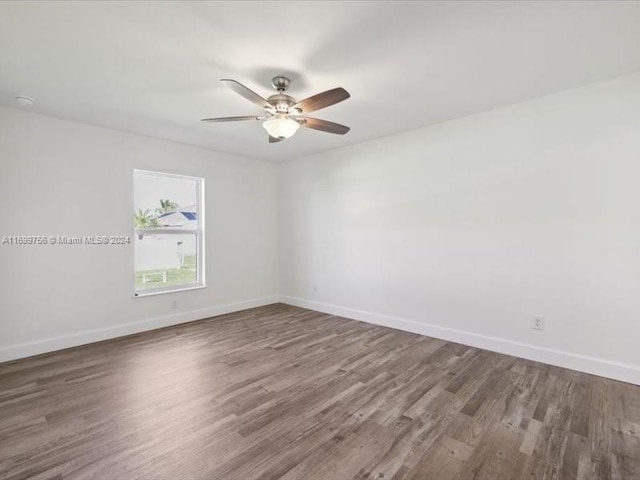 spare room with dark hardwood / wood-style floors and ceiling fan