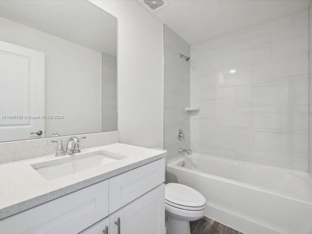 full bathroom with toilet, vanity, tiled shower / bath combo, and hardwood / wood-style flooring