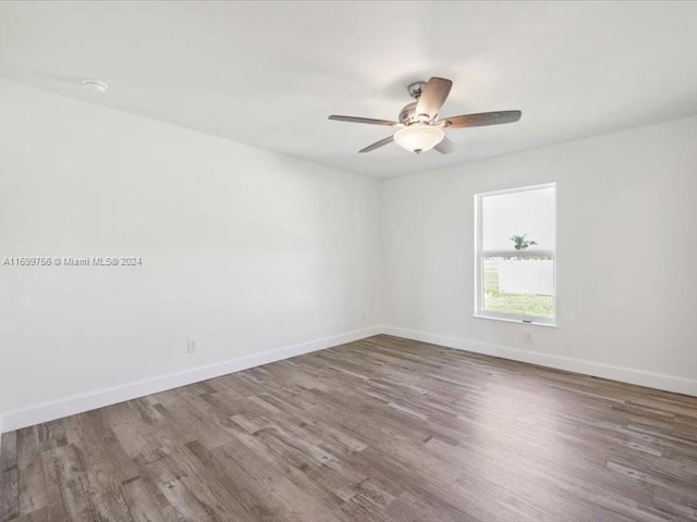 empty room with ceiling fan and hardwood / wood-style floors