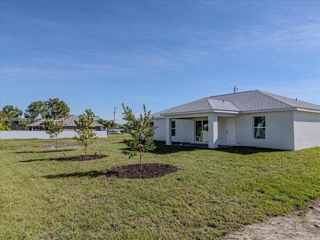 rear view of house featuring a yard