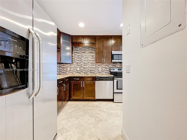 kitchen featuring backsplash, electric panel, dark brown cabinetry, and appliances with stainless steel finishes