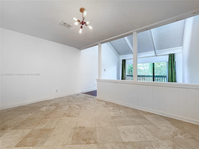 unfurnished room with lofted ceiling and a notable chandelier