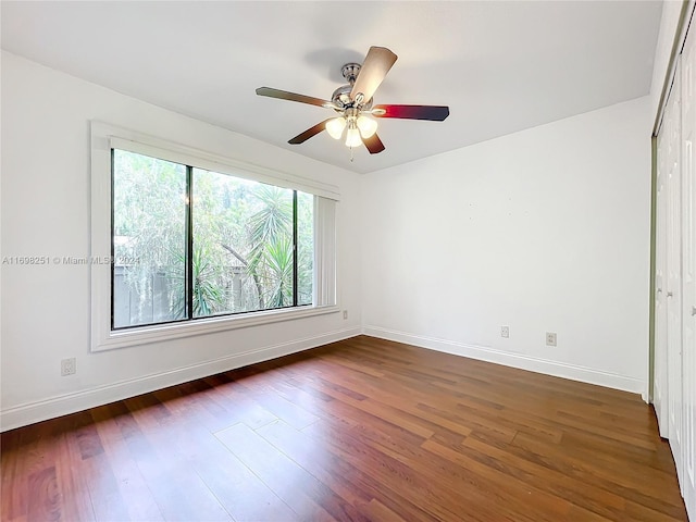 unfurnished room featuring ceiling fan and dark wood-type flooring