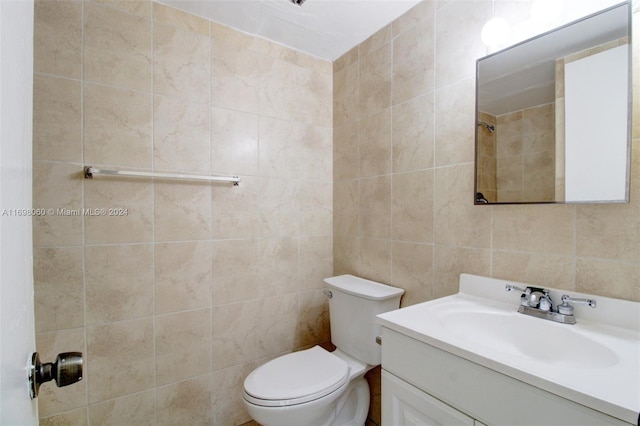 bathroom with vanity, tile walls, and toilet