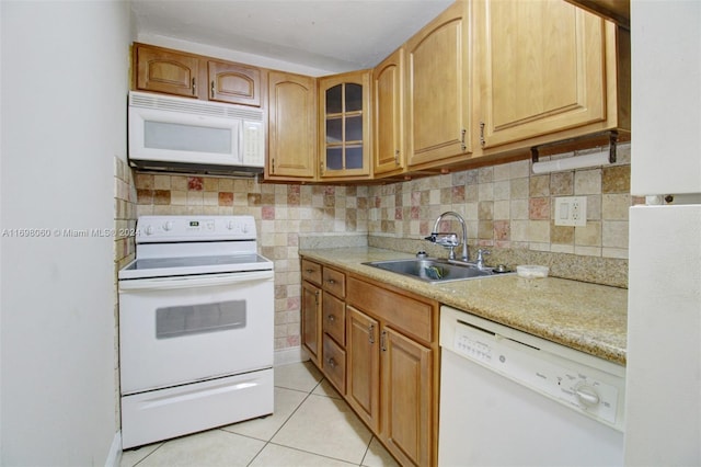 kitchen with light stone countertops, sink, tasteful backsplash, white appliances, and light tile patterned flooring