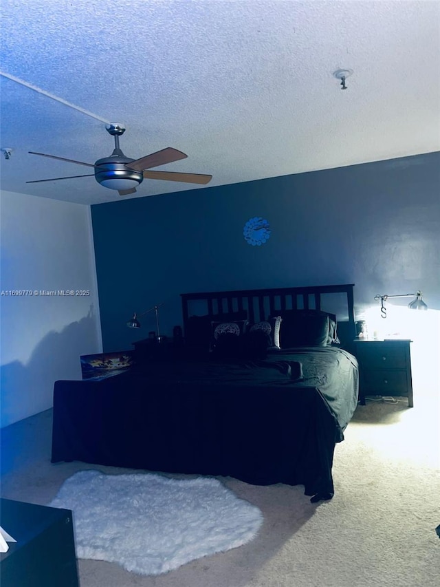 carpeted bedroom with ceiling fan and a textured ceiling