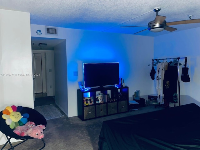 bedroom with ceiling fan, dark carpet, and a textured ceiling