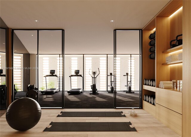 workout area featuring wood walls and floor to ceiling windows