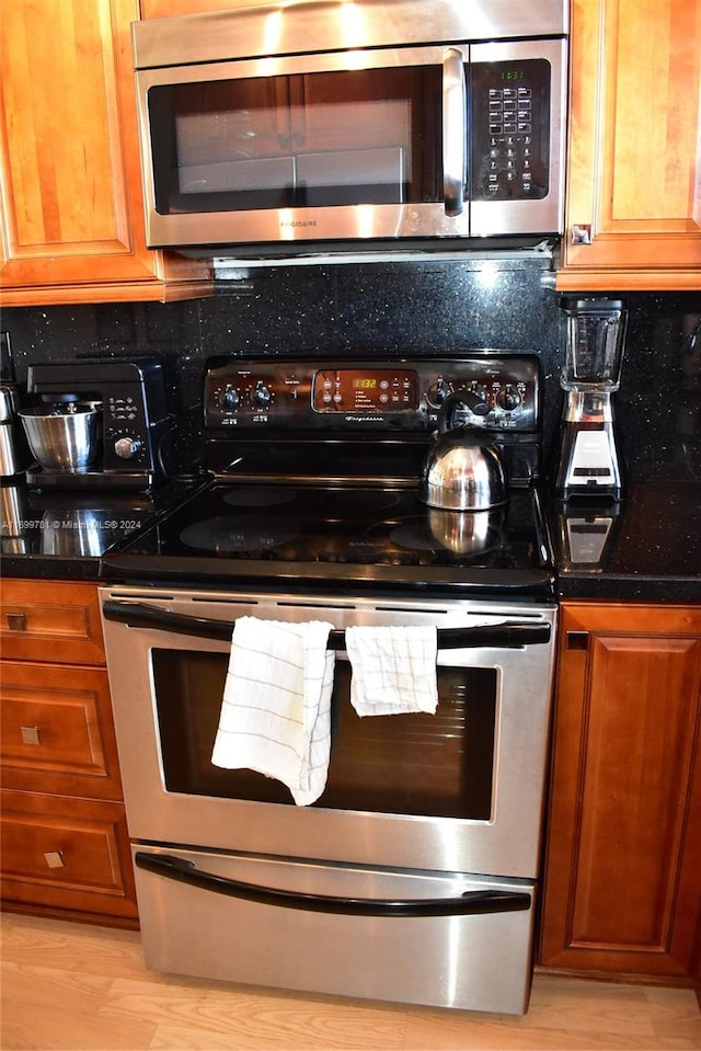 kitchen with appliances with stainless steel finishes and light hardwood / wood-style flooring