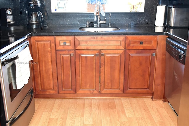 kitchen featuring decorative backsplash, sink, stainless steel appliances, and light wood-type flooring