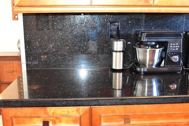 details with decorative backsplash, dark stone countertops, and sink