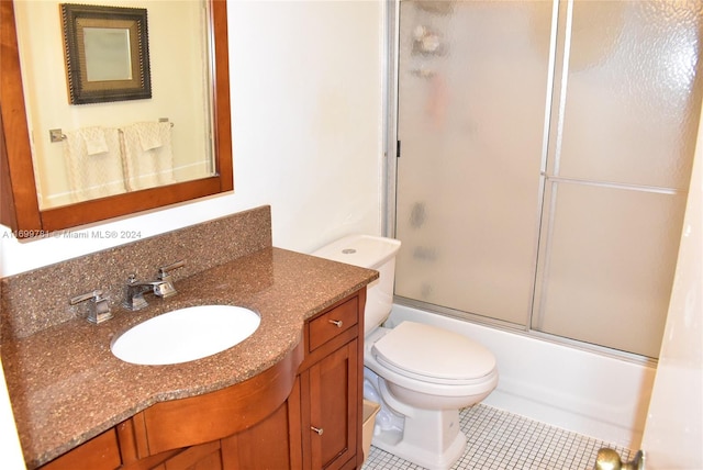 full bathroom with tile patterned floors, vanity, enclosed tub / shower combo, and toilet